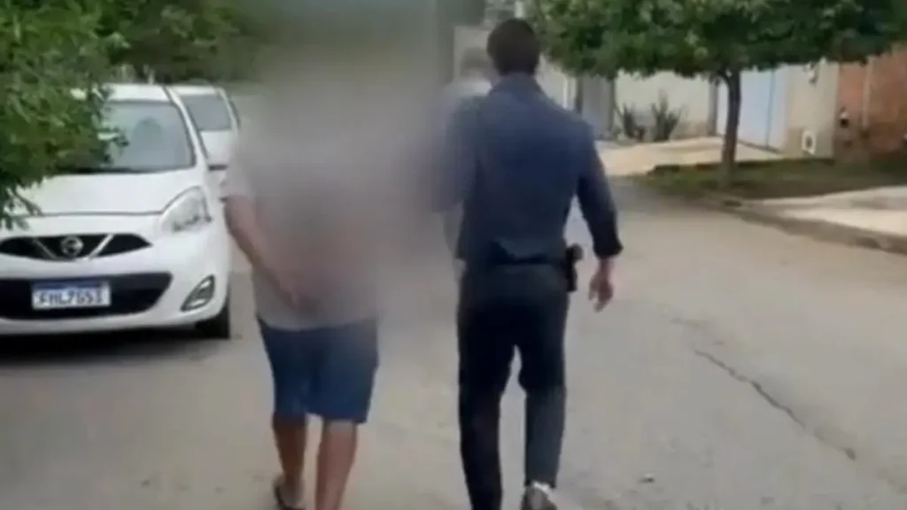 Idoso sendo conduzido pelo delegado - (Foto: divulgação/PC)