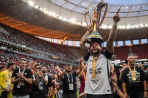 Foto colorida dos jogadores do Corinthians levantando a taça da Supercopa do Brasil - Metrópoles