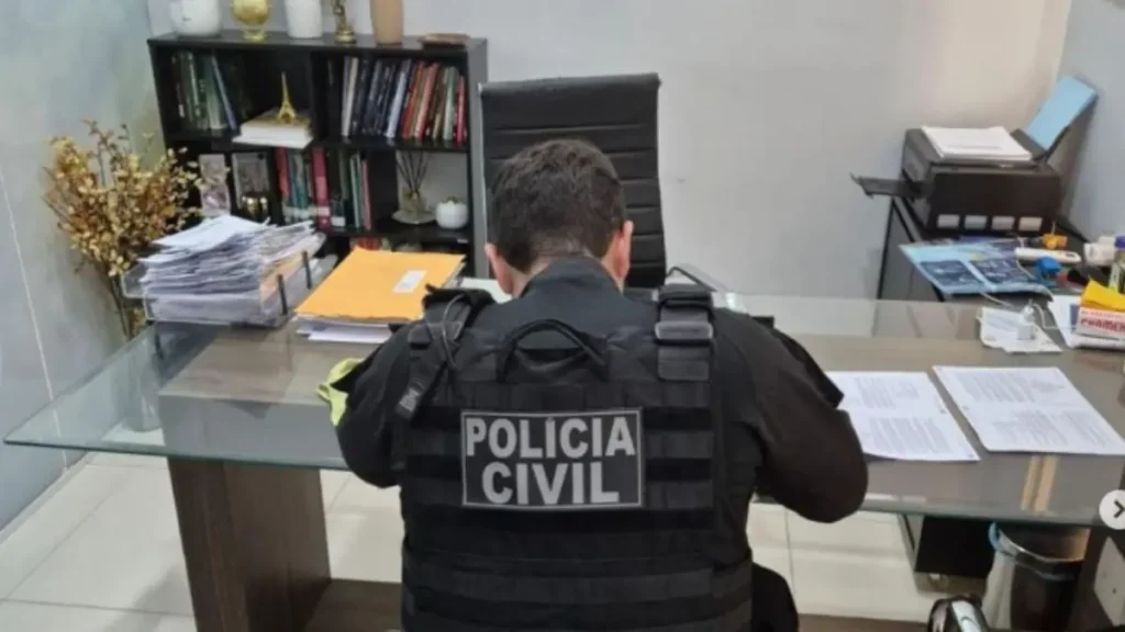 Imagem mostra agente durante cumprimento de mandado no escritório da suspeita