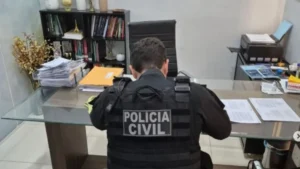 Imagem mostra agente durante cumprimento de mandado no escritório da suspeita