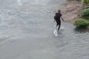 Homens se arriscam no córrego da marginal Botafogo, em Goiânia