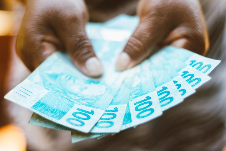 Pessoa segura notas de dinheiro