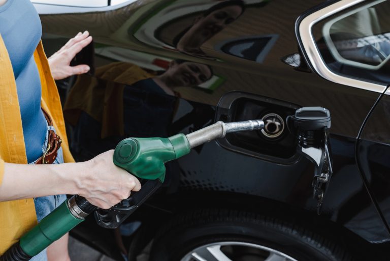 Mulher abastece o carro num posto de gasolina