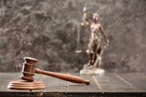 Martelo de juiz e uma estátua da justiça em cima de uma mesa