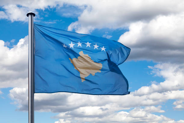 close up on the flag of kosovo waving atop of its pole.